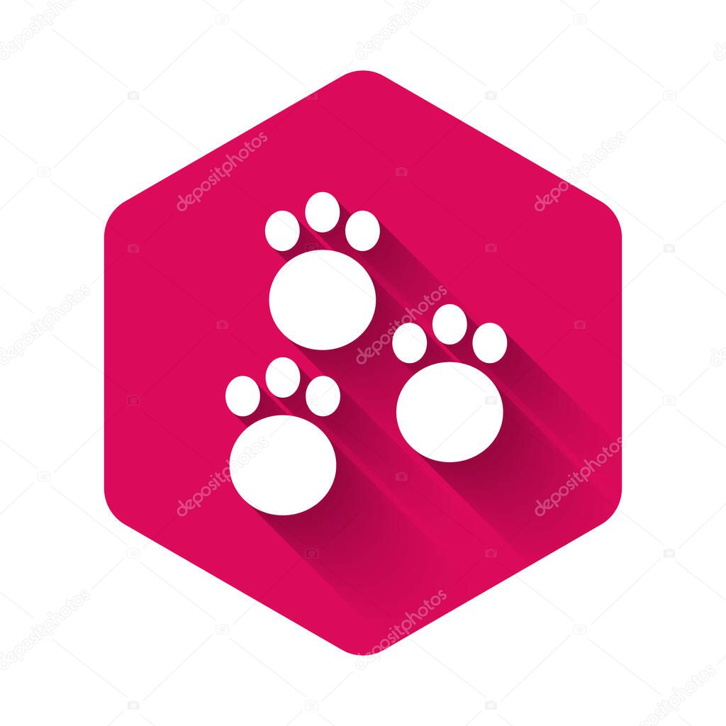 White Paw print icon isolated with long shadow. Dog or cat paw print. Animal track. Pink hexagon button. Vector.