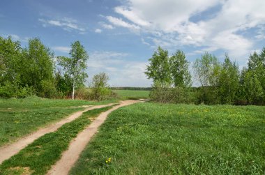 Yeşil alanları ve ormanları ile beyaz bulutlar mavi gökyüzü altında
