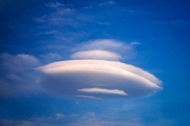 Ufo-shaped cloud against blue sky on Crete Island in Greece clipart