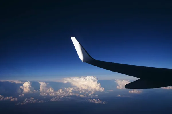 在云层上空飞行时从乘客平面的窗口看 — 图库照片