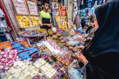 Shiraz, Iran - October 23, 2016: Woman buys sweets on the Hadji Bazaar in Shiraz clipart