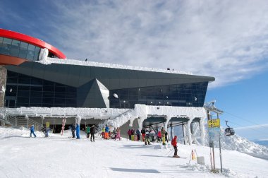 Skiers at the Chopok cable car station on a winter sunny day in  clipart