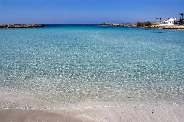 Beyaz kumlu plaj ve mavi şeffaf deniz ile Deniz Manzarası, Kıbrıs — Stok fotoğraf