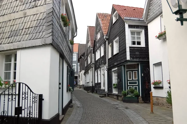 Em uma pequena rua com casas de madeira histórica quadro em reboque velho — Fotografia de Stock