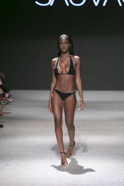 Manken Sauvage yaz koleksiyonu 2018 defile sırasında sanat kalpler moda yüzmek 2019 Miami Beach Faena Forum üzerinde 13 Temmuz 2018 için pist yürür