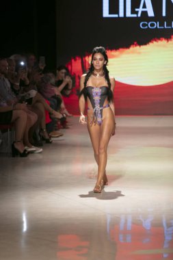 15 Temmuz 2018'de Miami Beach'teki Faena Forum'da Sanat, Kalpler ve Moda Yüzme 2018 koleksiyonunda Lila Nikole Fashion Show Suumer 2019 koleksiyonunda podyumda yürüyen bir manken