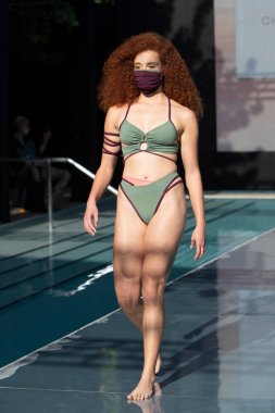 20 Ağustos 2020 'de Miami Beach' teki SLS Oteli 'nde kutlanan CDC yönergelerine göre Covid-19 pandemisinin ilk yüz yüze defilesi olan Paraiso Miami Beach Upcycle Challenge Sunumu sırasında bir manken podyumda yürüyor.