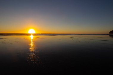 Piha plajında gün batımı, North Island, Yeni Zelanda