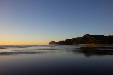 Piha plajında gün batımı, North Island, Yeni Zelanda