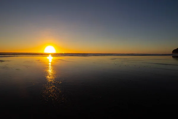 Coucher de soleil sur la plage de Piha, île du Nord, Nouvelle-Zélande — Photo