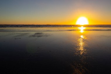 Piha plajında gün batımı, North Island, Yeni Zelanda