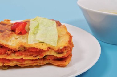 Mavi bir arka plan üzerinde sebzeli lazanya