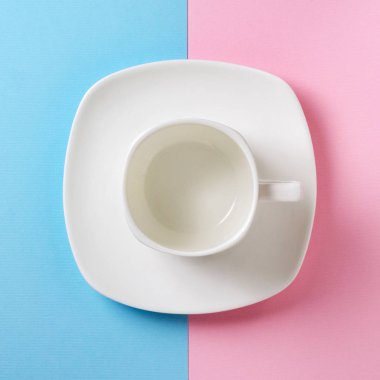Boş beyaz Kupası ve fincan tabağı pembe ve mavi arka plan üzerinde. Düz yatıyordu kavramı. Pastel tonları