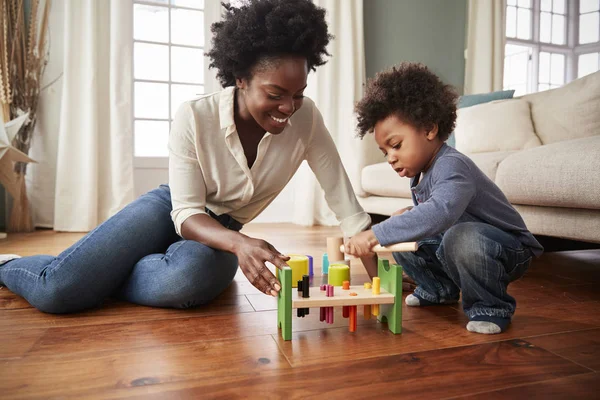 母親と幼い息子が家で木のおもちゃと遊ぶ — ストック写真