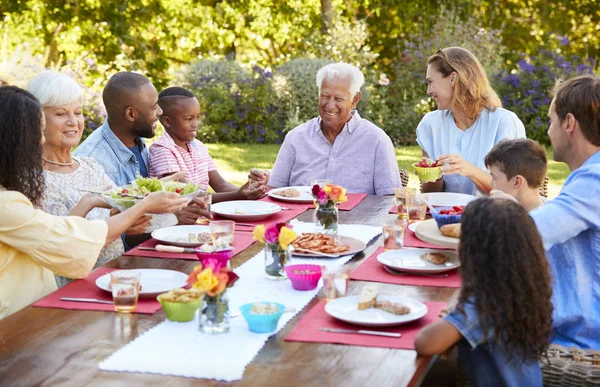 家人和朋友在花园餐桌上吃午餐 — 图库照片