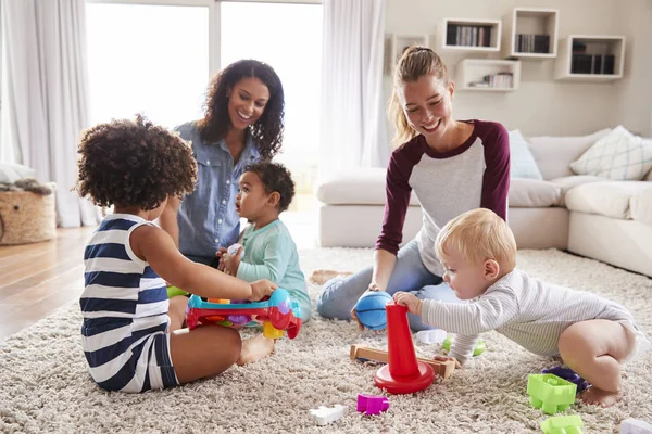 Due Amici Che Giocano Con Bambini Piccoli Sul Pavimento Del — Foto Stock