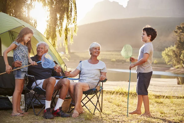 湖でキャンプの休日で祖父母と孫 — ストック写真