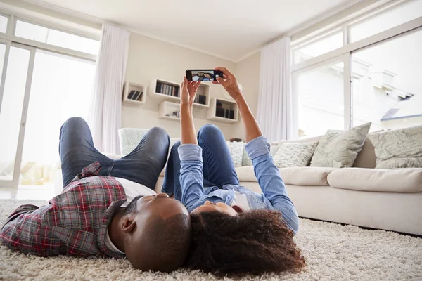 Pár Ležel Koberci Pózuje Pro Selfie Doma — Stock fotografie