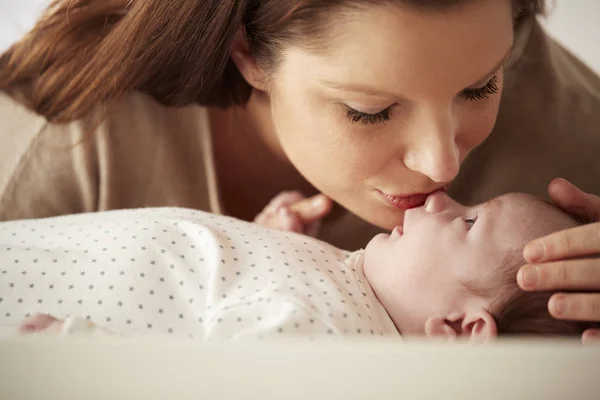 Mãe Beijando Bebê Recém Nascido Deitado Mesa Mudança Berçário — Fotografia de Stock