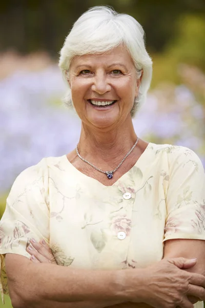 Portret Van Senior Vrouw Genieten Van Wandeling Langs Bloemenperken Park — Stockfoto
