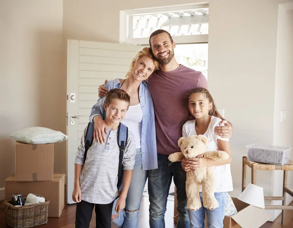 Portrait Of Family In Lounge Of New Home On Moving Day