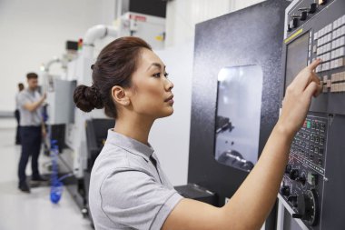 Female Engineer Operating CNC Machinery In Factory clipart