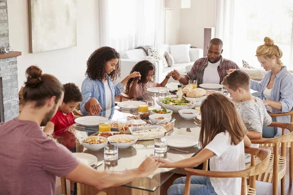两个家庭一起在家里吃饭之前祈祷 — 图库照片