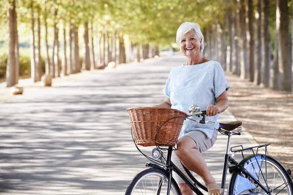 Retrato Smiling Senior Mujer Ciclismo Country Road — Foto de Stock