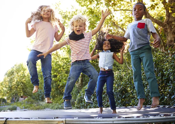 Empat Anak Bersenang Senang Bersama Sama Pada Trampolin Kebun — Stok Foto