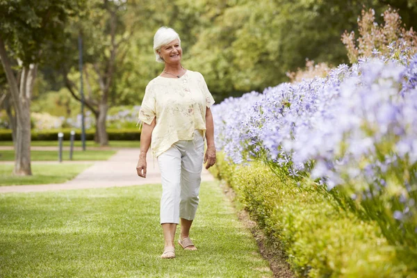 Senior Vrouw Genieten Van Wandeling Langs Bloemenperken Park — Stockfoto