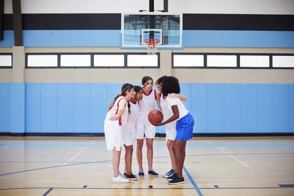 チームを持つハドルで女子高校バスケット ボール選手がコーチと話す — ストック写真