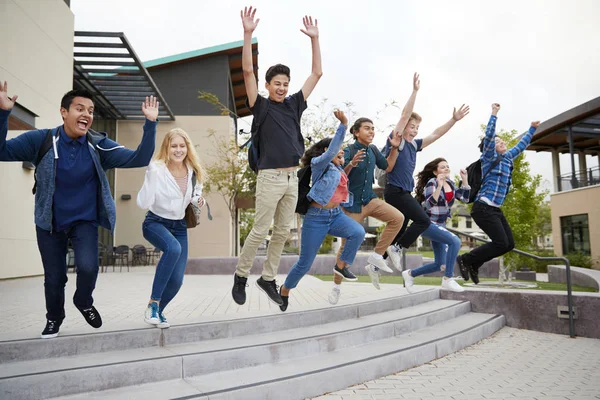 Grupp Gymnasieelever Som Hoppar Luften Utanför College Byggnader — Stockfoto