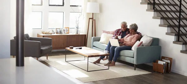 Casal Sênior Sentado Sofá Casa Usando Laptop Para Comprar Line — Fotografia de Stock