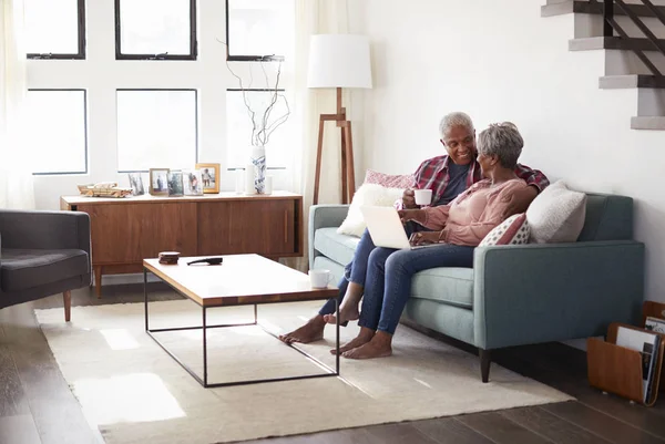 Seniorenpaar Sitzt Hause Auf Sofa Und Kauft Mit Laptop Online — Stockfoto