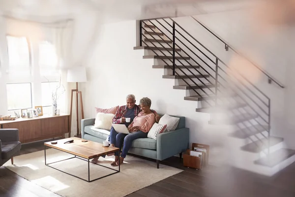 Seniorenpaar Sitzt Hause Auf Sofa Und Kauft Mit Laptop Online — Stockfoto