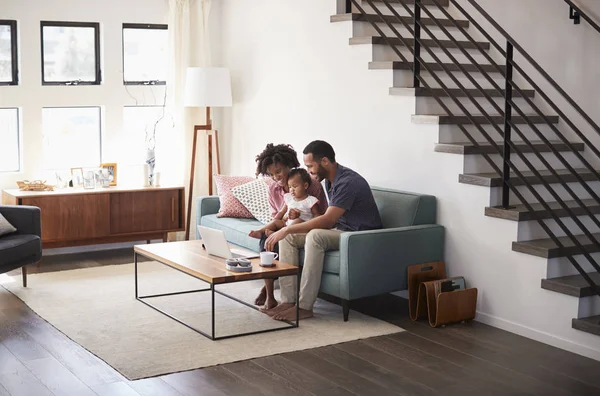 Família Com Filha Bebê Sentada Sofá Casa Olhando Para Computador — Fotografia de Stock
