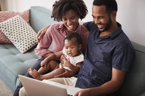 Familj Med Baby Dotter Sitta Soffan Hemma Tittar Bärbar Dator — Stockfoto