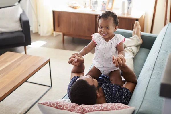 Father Lying Sofa Home Playing Baby Daughter — Stock Photo, Image