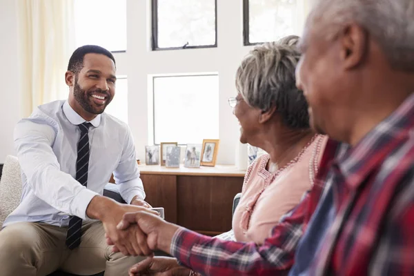 Senior Paar Schudden Handen Met Mannelijke Financieel Adviseur Bij Thuis — Stockfoto