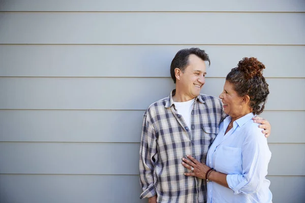 外の灰色の下見板張りの家に立っている年配のカップル — ストック写真
