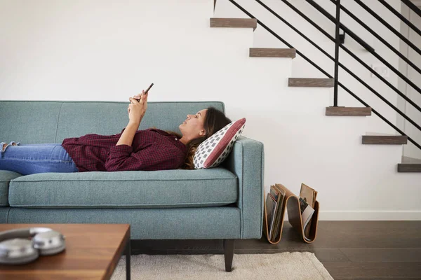 Zijaanzicht Van Vrouw Liggend Bank Thuis Mobiele Telefoon — Stockfoto