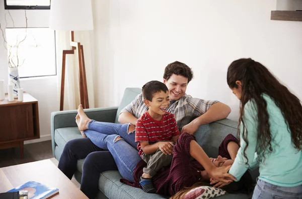 Família Divertindo Deitada Sofá Casa Juntos — Fotografia de Stock