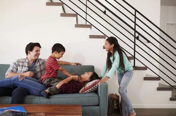 Familia Divirtiéndose Acostados Sofá Casa Juntos — Foto de Stock