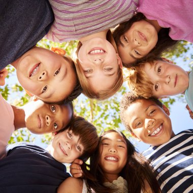 Group of kids outdoors looking down at camera clipart