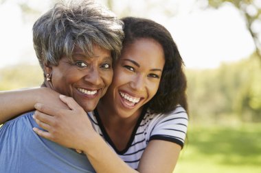 Portrait Of Senior Mother With Adult Daughter Hugging In Park  clipart