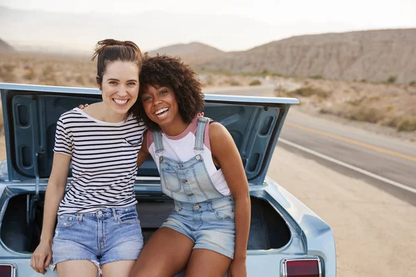 Portrait Two Female Friends Sitting Trunk Classic Car Road Trip — стоковое фото