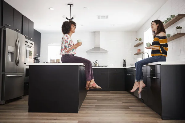 Duas Amigas Encontram Para Tomar Café Casa Sentadas Ilha Cozinha — Fotografia de Stock