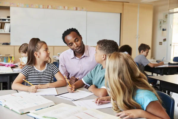 Lärare Som Arbetar Med Folkskolan Barn Skrivbord — Stockfoto