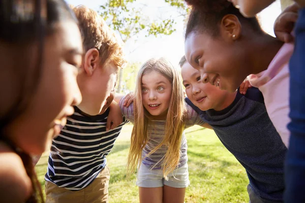 Multi-ethnic group of kids embracing, looking at each other