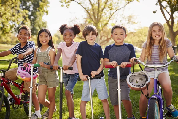 Enfants École Primaire Sur Vélos Scooters Dans Parc — Photo